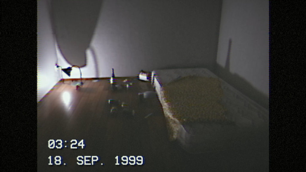 September 1999 Screenshot Showing a Mattress in a Dark Room With Bottles nearby
