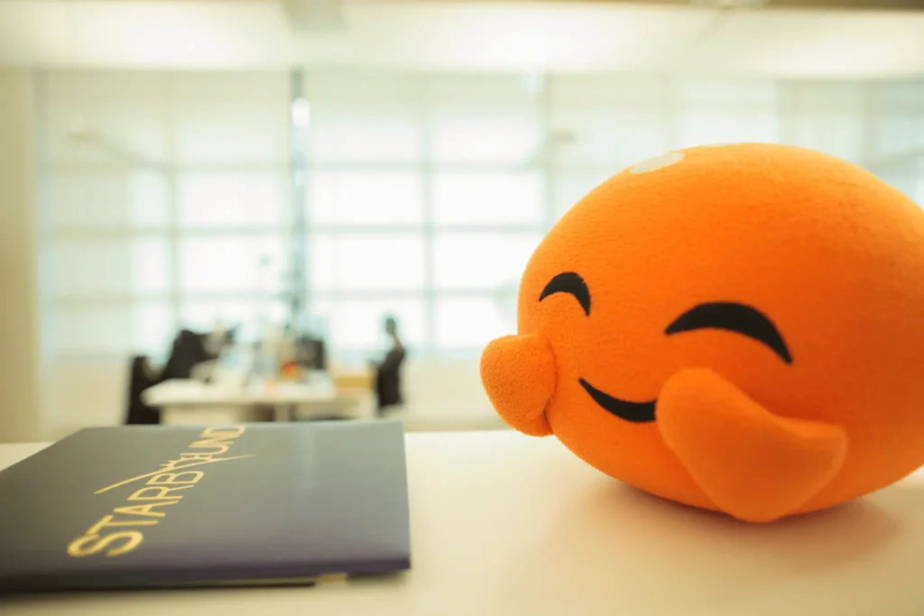 Picture of an Orange Plushy Smiling While on a Table