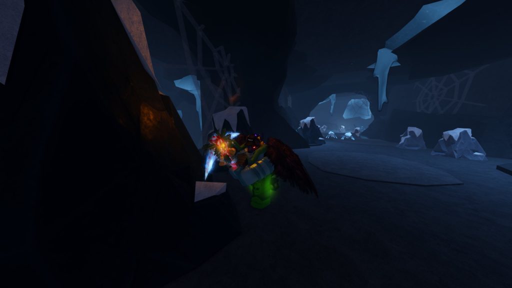 The Forge screenshot inside an icy blue cave with a couple of crystal spiders in the distance. Up close is a Roblox character with red wings mining a large rock.